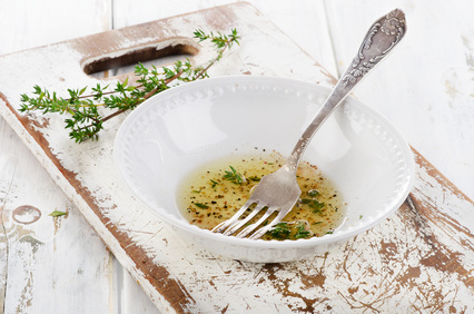 Dressing with thyme in a white bowl. Selective focus